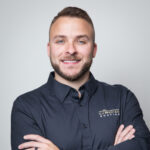 Smiling man in black shirt with Guardian Roofing logo